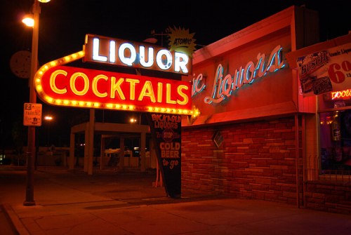 Neon sign for a liquor store at night, featuring "Liquor" and "Cocktails" in bright, colorful lights.