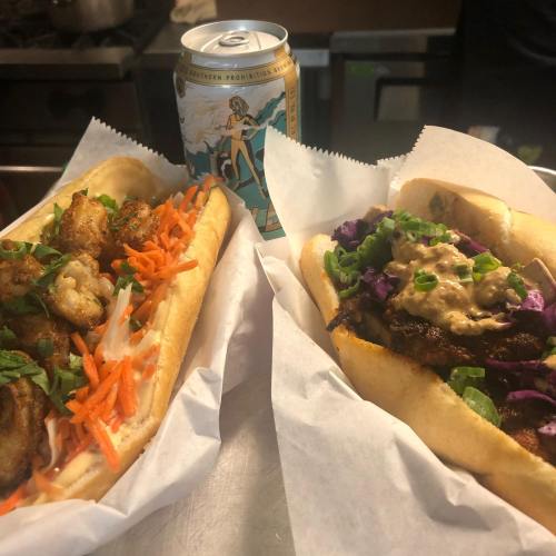 Two delicious sandwiches filled with vegetables, served with a can of soda in the background.