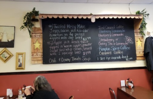 Chalkboard menu featuring breakfast and drink options, including "Twisted Messy Mike" and various coffee flavors.