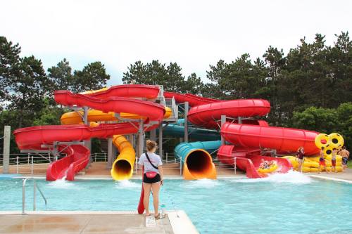A water park featuring colorful slides and a swimming pool, with a lifeguard on duty nearby.