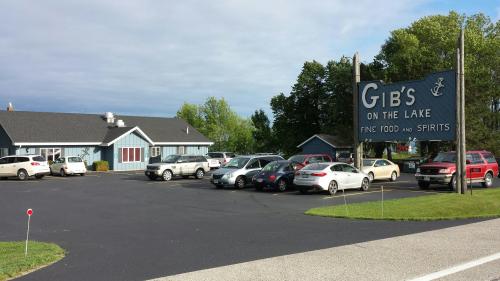 A restaurant called "Gib's on the Lake" with a large sign, surrounded by parked cars and greenery.