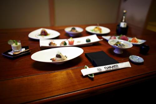 A beautifully arranged table with various elegant dishes, sake, and utensils in a traditional dining setting.