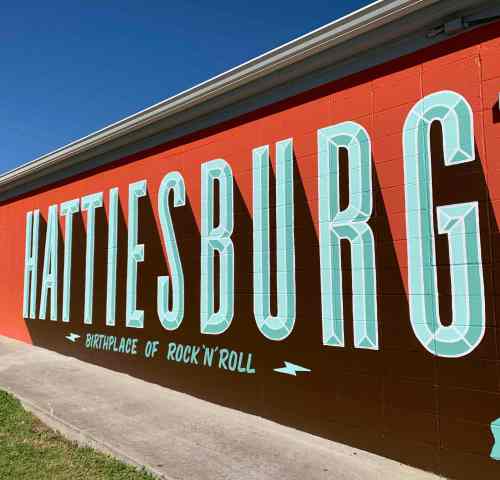 Mural on a wall reading "HATTIESBURG, BIRTHPLACE OF ROCK 'N' ROLL" in bold, colorful letters.