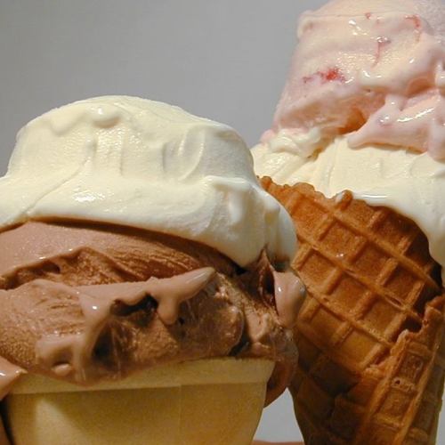 Two ice cream cones: one with chocolate and vanilla swirls, the other with strawberry and vanilla.