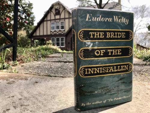 A book titled "The Bride of the Innissfallen" by Eudora Welty, with a house in the background.