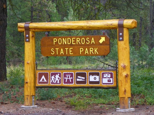 Sign for Ponderosa State Park with directional arrow and icons for camping, hiking, and photography.