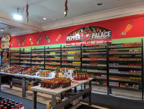 A vibrant hot sauce shop with colorful shelves filled with various hot sauces and a bold sign reading "Pepper Palace."