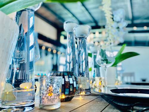 A beautifully set table with glass vases, candles, and decorative elements, creating an elegant dining atmosphere.