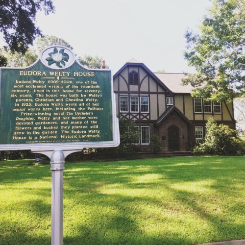 Historic Eudora Welty House with a plaque detailing the author's legacy and her family's gardening influence.