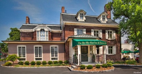 Historic inn with a green awning, brick facade, and landscaped front yard. The sign reads "The Ho-Ho-Kus Inn & Tavern."