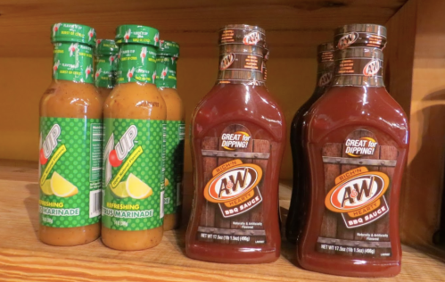 Bottles of 7UP marinade and A&W BBQ sauce on a wooden shelf.