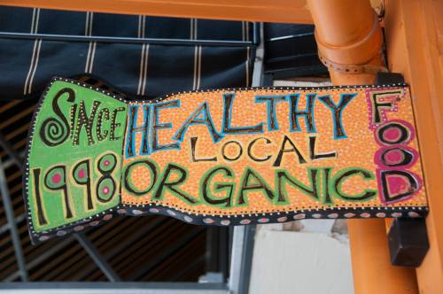 Colorful sign promoting healthy, local, and organic food since 1998.