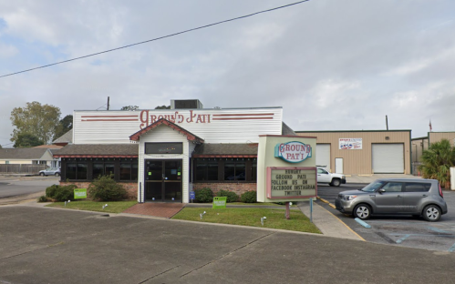 Exterior of Ground Pat, a restaurant with a sign, surrounded by parking and a cloudy sky.