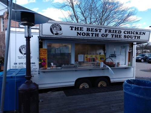 A food truck named "The Best Fried Chicken North of the South" with a menu displayed outside.