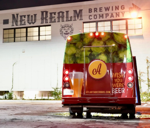 A colorful food truck parked outside New Realm Brewing Company, featuring a playful beer-themed design.
