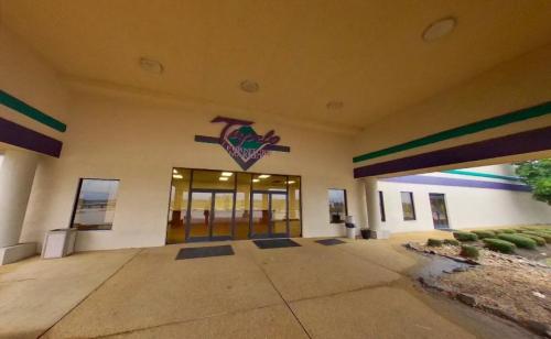 Entrance of a building with a sign reading "Tyler" and large glass doors, surrounded by a landscaped area.