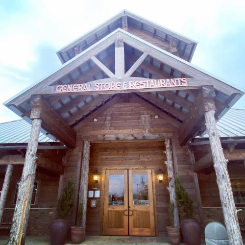 Front view of a rustic general store and restaurant with wooden beams and a welcoming entrance.
