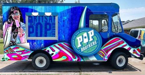 Colorful ice cream truck featuring a vibrant design and a cartoon character holding a popsicle.