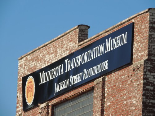 Sign for the Minnesota Transportation Museum, featuring "Jackson Street Roundhouse," on a brick building.