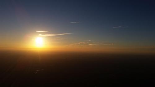 A serene sunset over a hazy horizon, with warm colors blending into a clear blue sky.