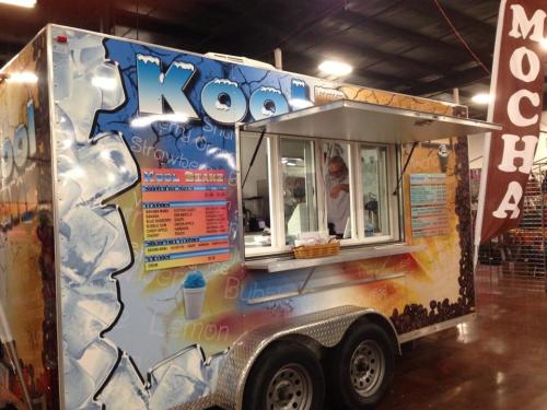 A colorful food truck named "Kool" with a menu featuring shaved ice and coffee drinks, set in an indoor market.