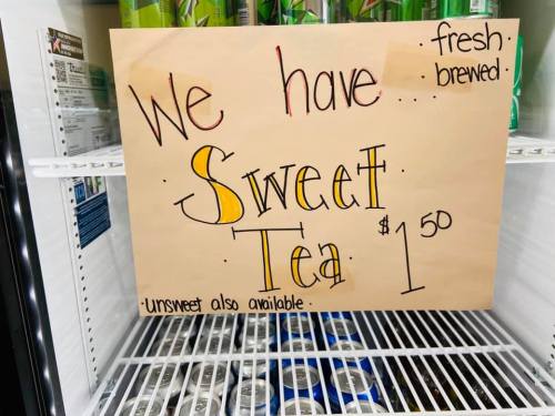 Sign in a fridge advertising fresh brewed sweet tea for $1.50, with unsweetened option also available.