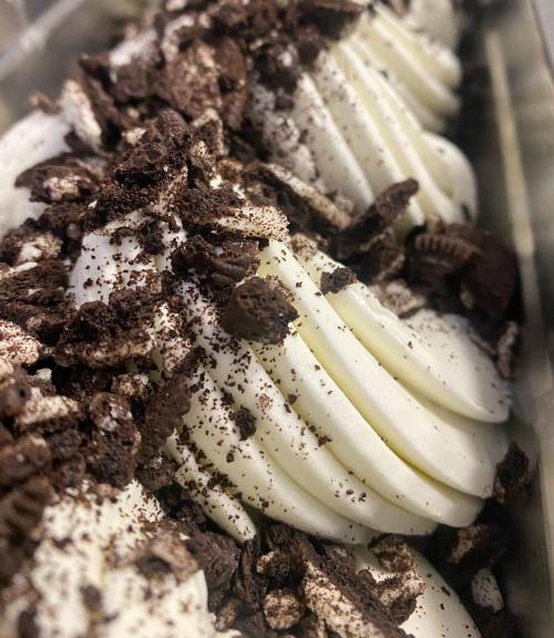 Close-up of creamy white dessert topped with crushed Oreo cookies, creating a textured and indulgent appearance.