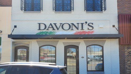 Exterior of Davoni's restaurant, featuring a sign with Italian colors and a modern brick facade.