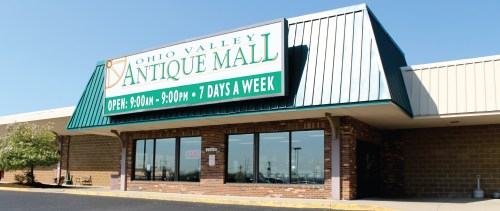 Exterior of Ohio Valley Antique Mall with a large sign displaying hours and "Open 7 Days a Week." Clear blue sky above.
