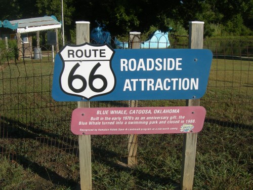 Sign for Route 66 Roadside Attraction featuring the Blue Whale in Catoosa, Oklahoma, with historical details.