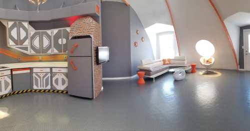 A modern, futuristic kitchen and living area with gray and orange accents, featuring sleek furniture and unique decor.