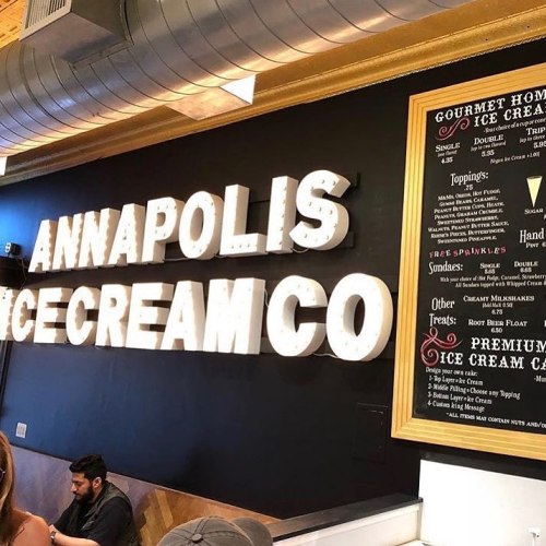 Sign for Annapolis Ice Cream Co. with a menu featuring gourmet ice cream options and toppings.