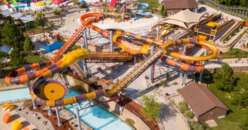 Aerial view of a colorful water park with multiple twisting water slides and a lazy river.