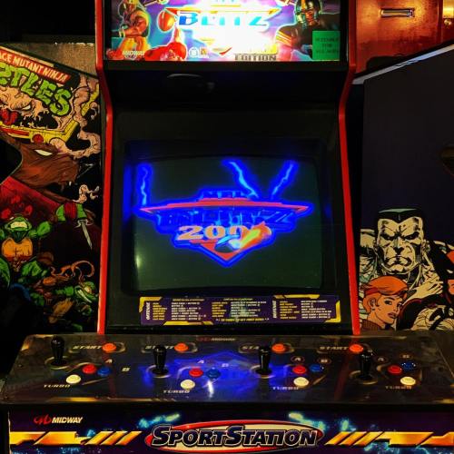 An arcade game cabinet featuring "NFL Blitz 2000" with colorful graphics and control buttons.