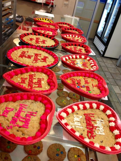 A display of heart-shaped cookies decorated for Valentine's Day, with messages like "Happy Valentine's Day!" in colorful icing.