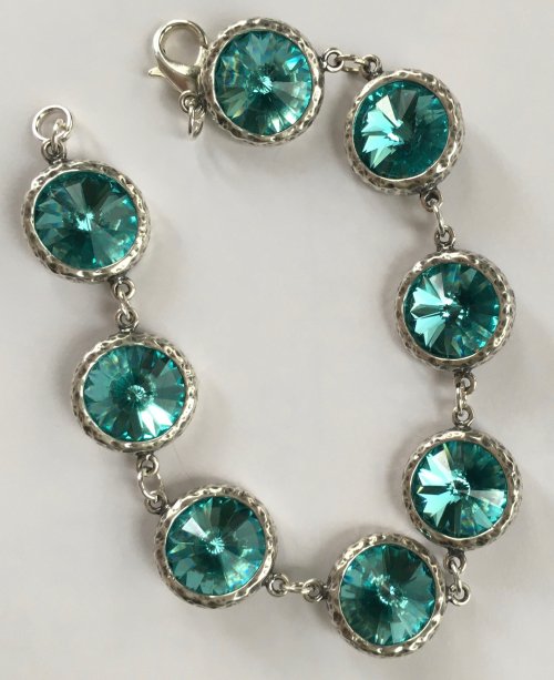 A silver bracelet featuring large, round turquoise gemstones set in circular frames.