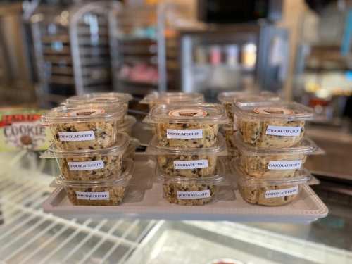 A display of clear containers filled with chocolate chip treats, arranged neatly on a white tray.
