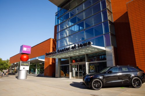 Exterior of the Science Center of Iowa, featuring a modern building and a black SUV parked in front.
