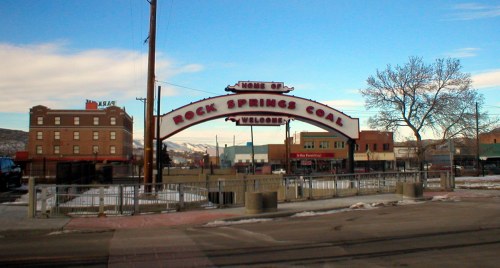 Welcome sign for Rock Springs Coal, with buildings and a clear blue sky in the background.