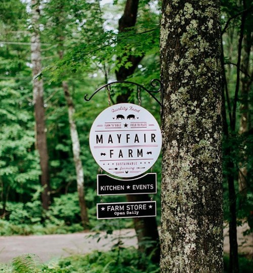 Sign for Mayfair Farm, featuring "Quality Food," "Sustainable," and details for kitchen, events, and farm store.