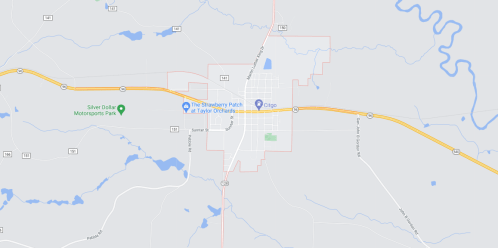 Map showing the layout of a small town with roads, parks, and nearby water features.