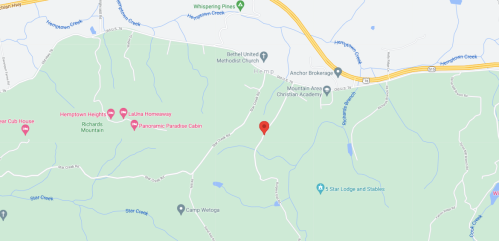 Map showing a green area with roads and landmarks, marked by a red pin indicating a specific location.