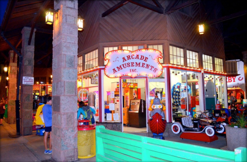 Brightly lit arcade entrance with colorful signage, games, and attractions, set in a lively indoor space.