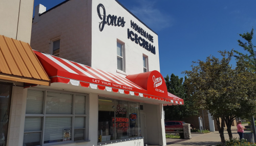 A quaint ice cream shop with a red and white awning, featuring the name "Jan's Homemade Ice Cream" on the building.