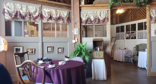 Cozy restaurant interior with elegant decor, tables set with white tablecloths, and vintage accents.
