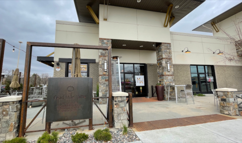 Exterior view of a modern restaurant with stone accents, outdoor seating, and a sign reading "Cead Mile Failte."