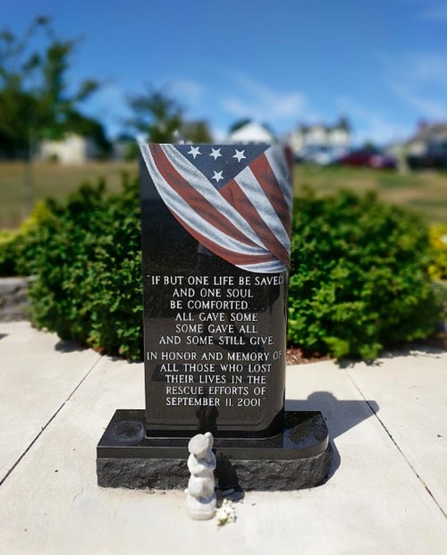A memorial stone with an American flag design, honoring those lost in the September 11, 2001 rescue efforts.