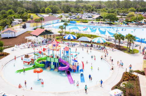 Aerial view of a vibrant water park with slides, pools, and families enjoying the sunny day.
