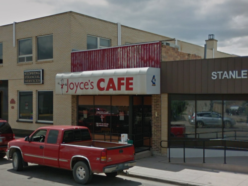 Exterior of Joyce's Cafe with a red truck parked outside, located in a brick building on a city street.