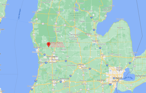 Map showing Michigan with a red marker indicating the location of Hilltop Bakery near Muskegon.